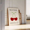 Red and orange paper-cut cherries in a mid-century style