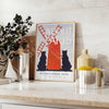 Vintage illustration of a Parisian street scene with gray and red hues - styled on a counter with eucalyptus and a bowl of lemons