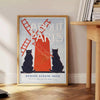 Vintage illustration of a Parisian street scene with gray and red hues - beside a round wooden side table with books