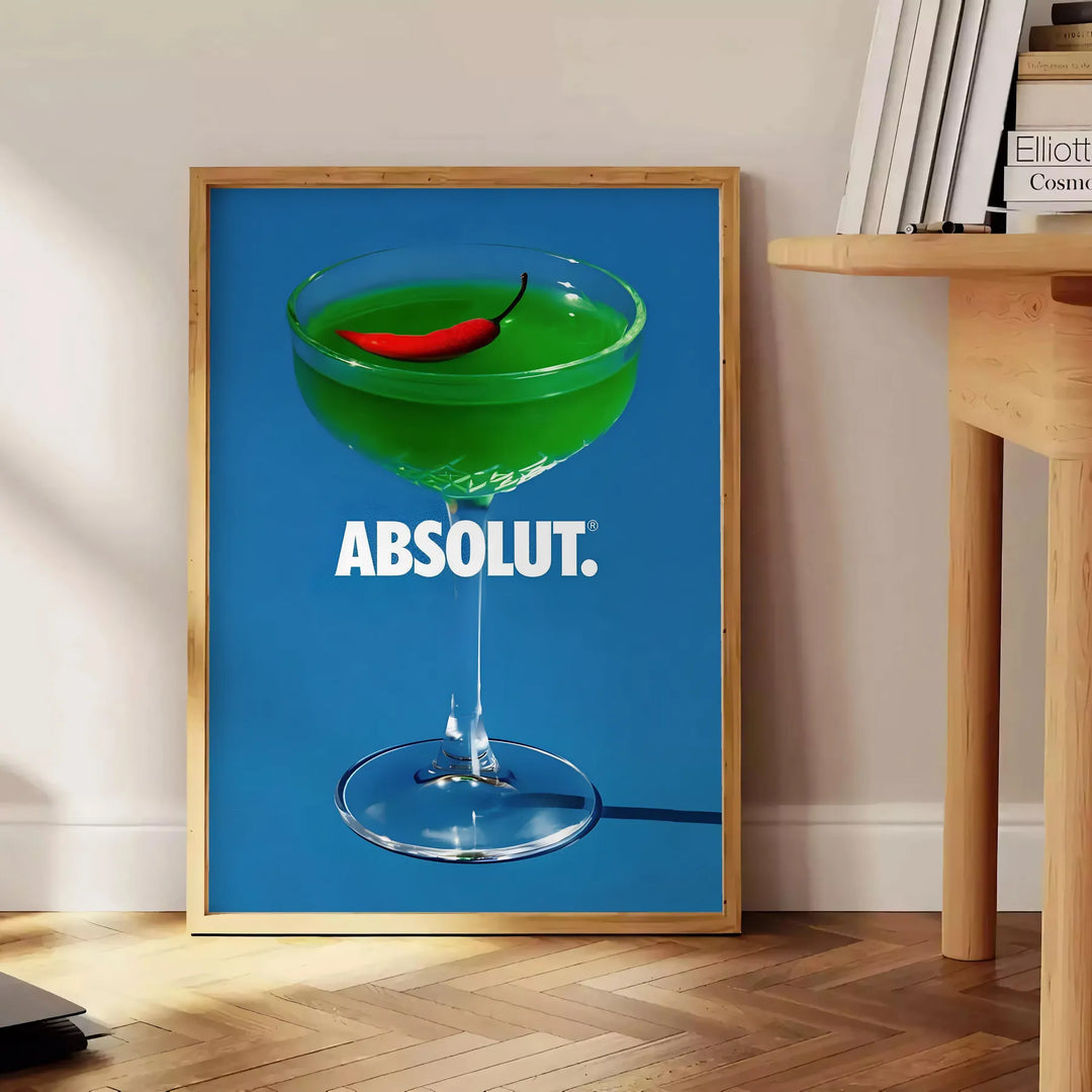 Poster of abstract cocktail artwork in brown and green tones, modern - beside a round wooden side table with books