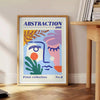 Maximalist abstract art featuring swirling shapes in blue and orange tones - beside a round wooden side table with books