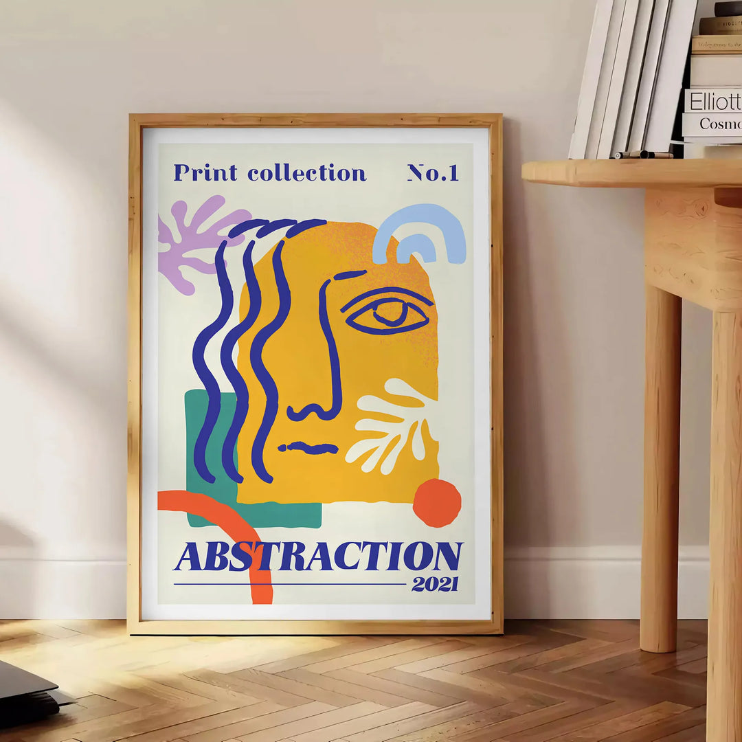 Yellow and orange maximalist abstract events poster with bold layered shapes - beside a round wooden side table with books