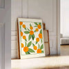 Green and white citrus kitchen poster, minimalist watercolor-style artwork - leaning on a herringbone floor against a white panelled wall