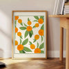 Green and white citrus kitchen poster, minimalist watercolor-style artwork - beside a round wooden side table with books