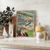 Sleek black and green airplane travel poster in minimalist graphic style - styled on a counter with eucalyptus and a bowl of lemons