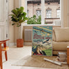 Sleek black and green airplane travel poster in minimalist graphic style - in a Parisian living room with a sofa and a fig plant