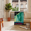 Stylized mountains and forest in shades of green and blue - in a Parisian living room with a sofa and a fig plant