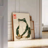 A green and orange frog with an angry expression in a retro space style - leaning on a herringbone floor against a white panelled wall