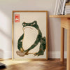 A green and orange frog with an angry expression in a retro space style - beside a round wooden side table with books