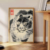 Woodblock-style poster of an angry tiger by Matsumoto Hoji with earthy tones - beside a round wooden side table with books