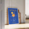 Aperol cocktail poster in bold blue and yellow modern abstract illustration - leaning on a herringbone floor against a white panelled wall
