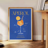 Aperol cocktail poster in bold blue and yellow modern abstract illustration - beside a round wooden side table with books