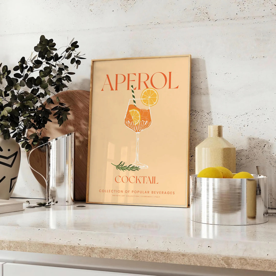 Poster showing stylized Aperol cocktail illustration in orange and gray tones - styled on a counter with eucalyptus and a bowl of lemons