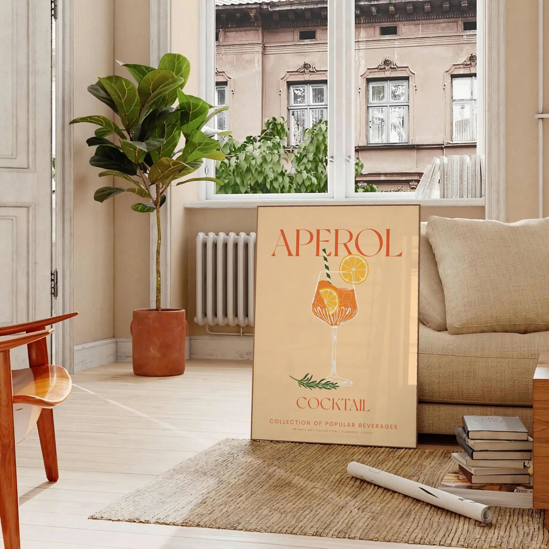 Poster showing stylized Aperol cocktail illustration in orange and gray tones - in a Parisian living room with a sofa and a fig plant