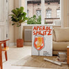 Poster raffigurante un Aperol Spritz stilizzato in arancione e nero - in un soggiorno parigino con divano e un ficus
