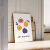 Bohemian kitchen art poster with gray and orange abstract composition - leaning on a herringbone floor against a white panelled wall