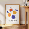 Bohemian kitchen art poster with gray and orange abstract composition - beside a round wooden side table with books