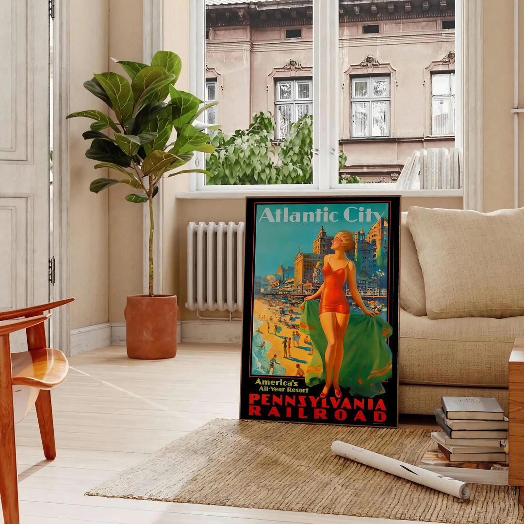 Retro travel poster depicting Atlantic City with seaside imagery in green and orange hues - in a Parisian living room with a sofa and a fig plant