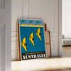Vintage Australia travel poster with bold yellow and black graphics - leaning on a herringbone floor against a white panelled wall