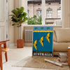 Vintage Australia travel poster with bold yellow and black graphics - in a Parisian living room with a sofa and a fig plant