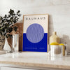 Minimal Bauhaus poster showing geometric shapes and bold composition - styled on a counter with eucalyptus and a bowl of lemons