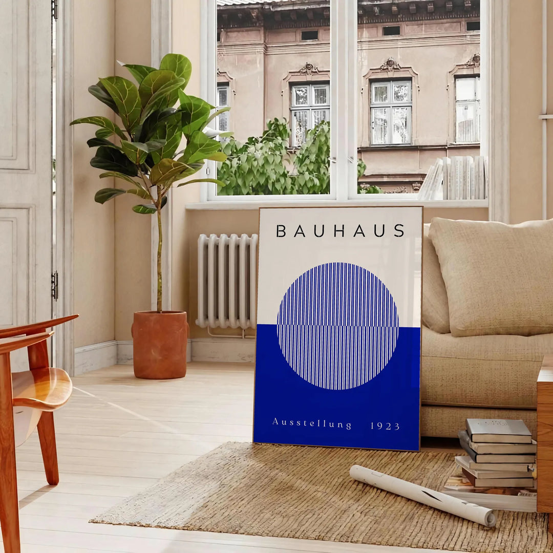 Minimal Bauhaus poster showing geometric shapes and bold composition - in a Parisian living room with a sofa and a fig plant