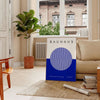 Minimal Bauhaus poster showing geometric shapes and bold composition - in a Parisian living room with a sofa and a fig plant