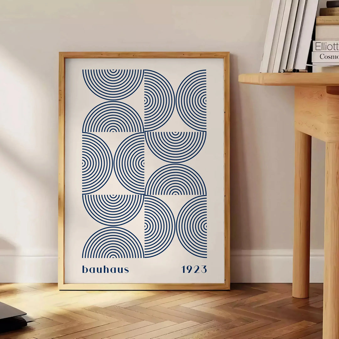 Bauhaus abstract poster with gray and blue geometric shapes, modern print - beside a round wooden side table with books