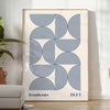 Bauhaus abstract poster with gray and blue geometric shapes, modern print - in a bright minimalist room with a plant and an armchair