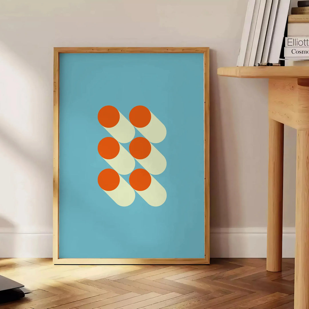 Bauhaus geometric abstract poster with bold red, blue, yellow shapes - beside a round wooden side table with books