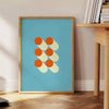 Bauhaus geometric abstract poster with bold red, blue, yellow shapes - beside a round wooden side table with books