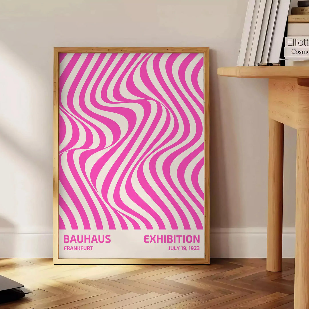 Unframed brown and pink Bauhaus geometric abstract poster - beside a round wooden side table with books