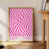 Unframed brown and pink Bauhaus geometric abstract poster - beside a round wooden side table with books