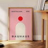 Bauhaus-Poster mit geometrischer abstrakter Komposition und minimalistischer Typografie - neben einem runden Beistelltisch aus Holz mit Büchern