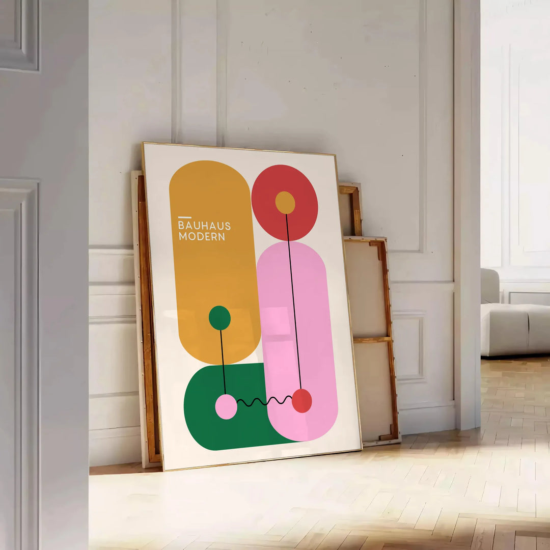 Bauhaus-geometrisches Poster mit abstrakten grünen und orangefarbenen Formen - an eine weiße Paneelwand gelehnt auf Fischgrätparkett