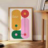 Bauhaus-geometrisches Poster mit abstrakten grünen und orangefarbenen Formen - neben einem runden Beistelltisch aus Holz mit Büchern