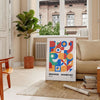 Bauhaus geometric abstract poster with orange and blue minimalist shapes - in a Parisian living room with a sofa and a fig plant