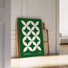 Green and white poster featuring abstract geometric shapes in Bauhaus style - leaning on a herringbone floor against a white panelled wall