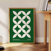 Green and white poster featuring abstract geometric shapes in Bauhaus style - beside a round wooden side table with books