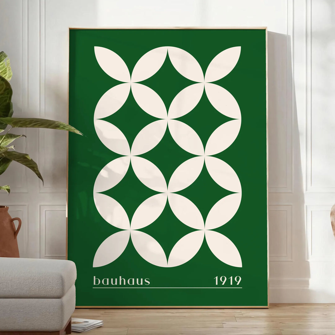 Green and white poster featuring abstract geometric shapes in Bauhaus style - in a bright minimalist room with a plant and an armchair
