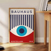 Bauhaus geometric poster with blue and red abstract shapes - beside a round wooden side table with books
