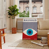 Bauhaus geometric poster with blue and red abstract shapes - in a Parisian living room with a sofa and a fig plant