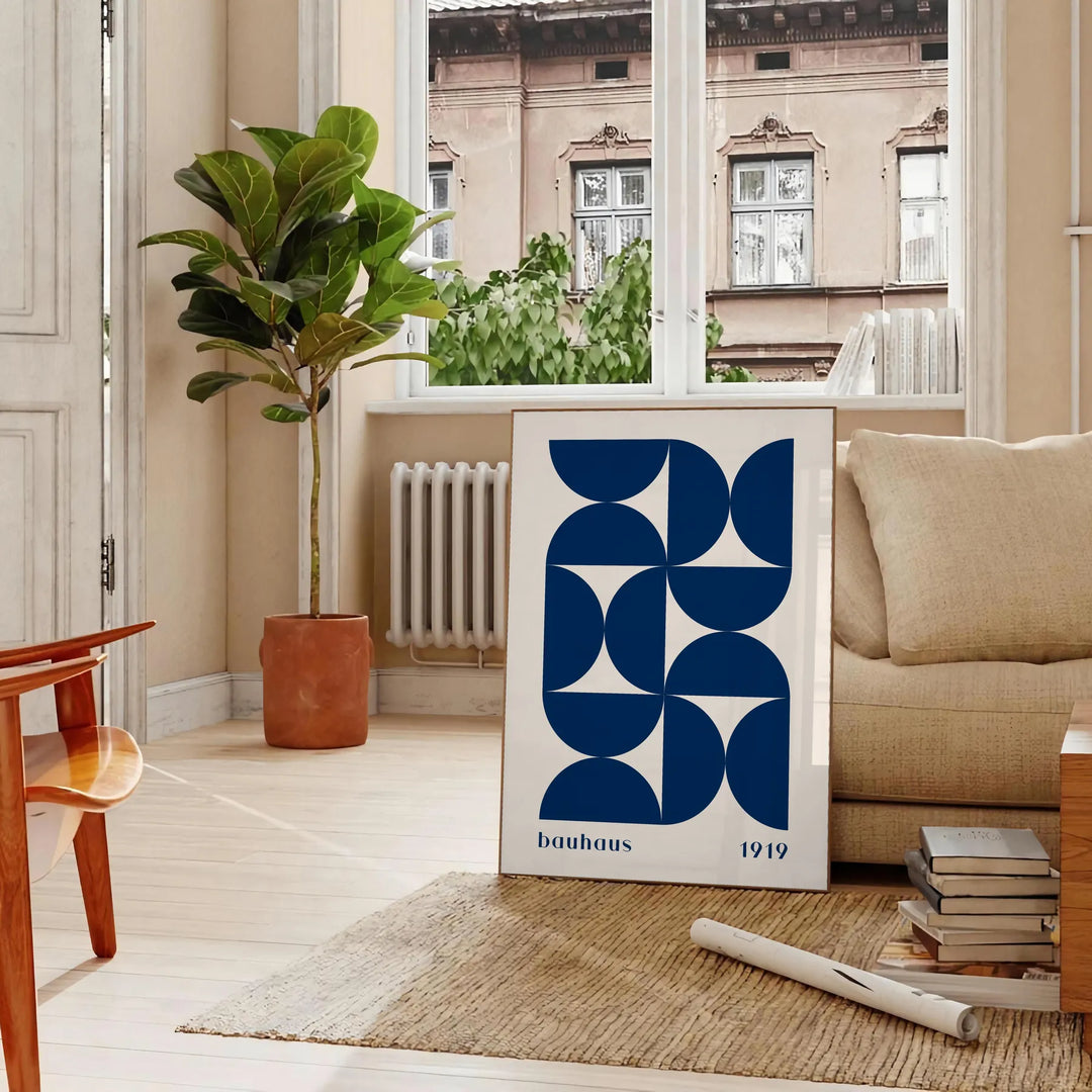 Vintage Bauhaus poster featuring geometric shapes in muted colors - in a Parisian living room with a sofa and a fig plant