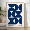 Vintage Bauhaus poster featuring geometric shapes in muted colors - in a bright minimalist room with a plant and an armchair