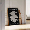Affiche Bauhaus montrant composition géométrique abstraite en rouge, bleu, jaune - posée sur un parquet à chevrons contre un mur à moulures
