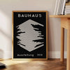 Affiche Bauhaus montrant composition géométrique abstraite en rouge, bleu, jaune - à côté d'une table d'appoint ronde en bois avec des livres