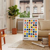 Bauhaus style abstract design with dynamic shapes in orange and blue - in a Parisian living room with a sofa and a fig plant