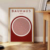Design astratto Bauhaus con forme geometriche in tonalità di grigio e marrone - accanto a un tavolino rotondo in legno con libri
