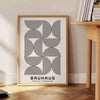Formas geométricas abstractas en gris y negro, inspiradas en el diseño Bauhaus - junto a una mesa auxiliar redonda de madera con libros