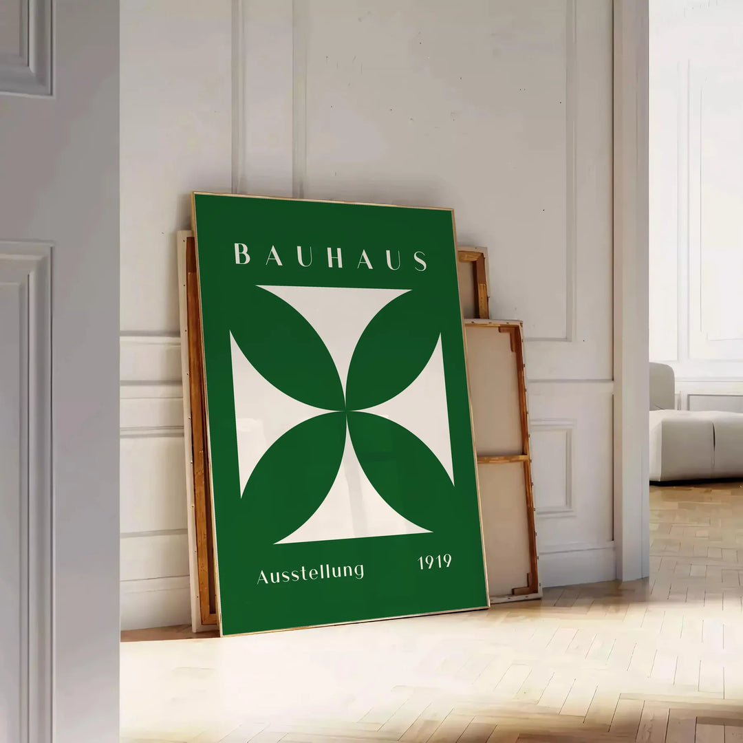 Abstraktes Bauhaus-Design mit geometrischen Formen in Grün und Weiß - an eine weiße Paneelwand gelehnt auf Fischgrätparkett